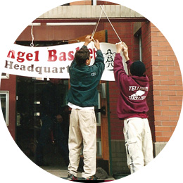 Two boys hanging a sign