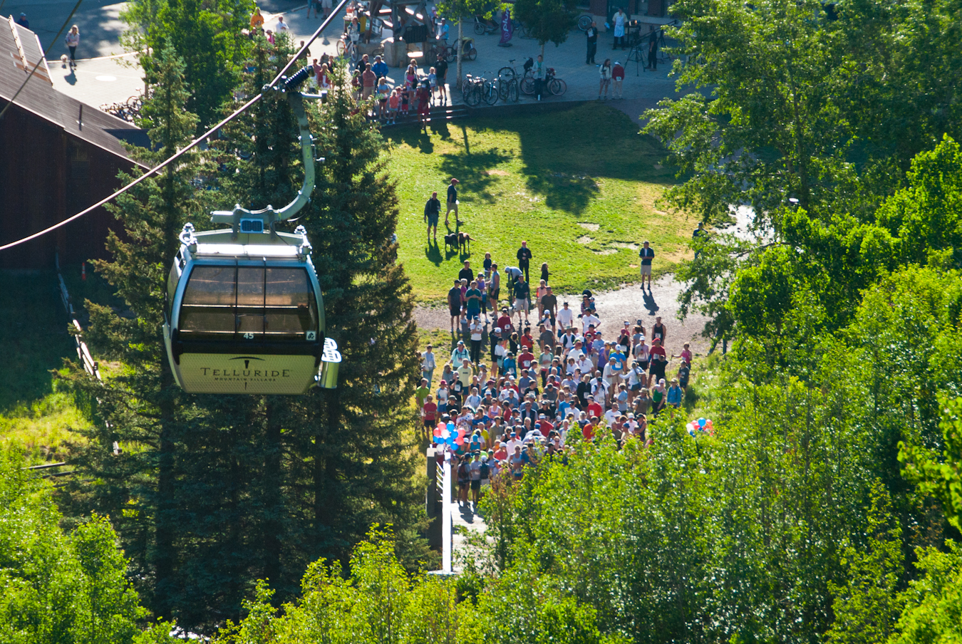 A gondola going up as people watch from the ground in Telluride Colorado