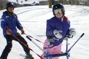 Adaptive sport coach helping female skier